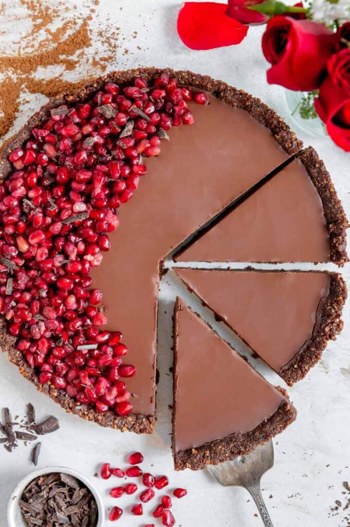 A vegan chocolate tart with three slices.