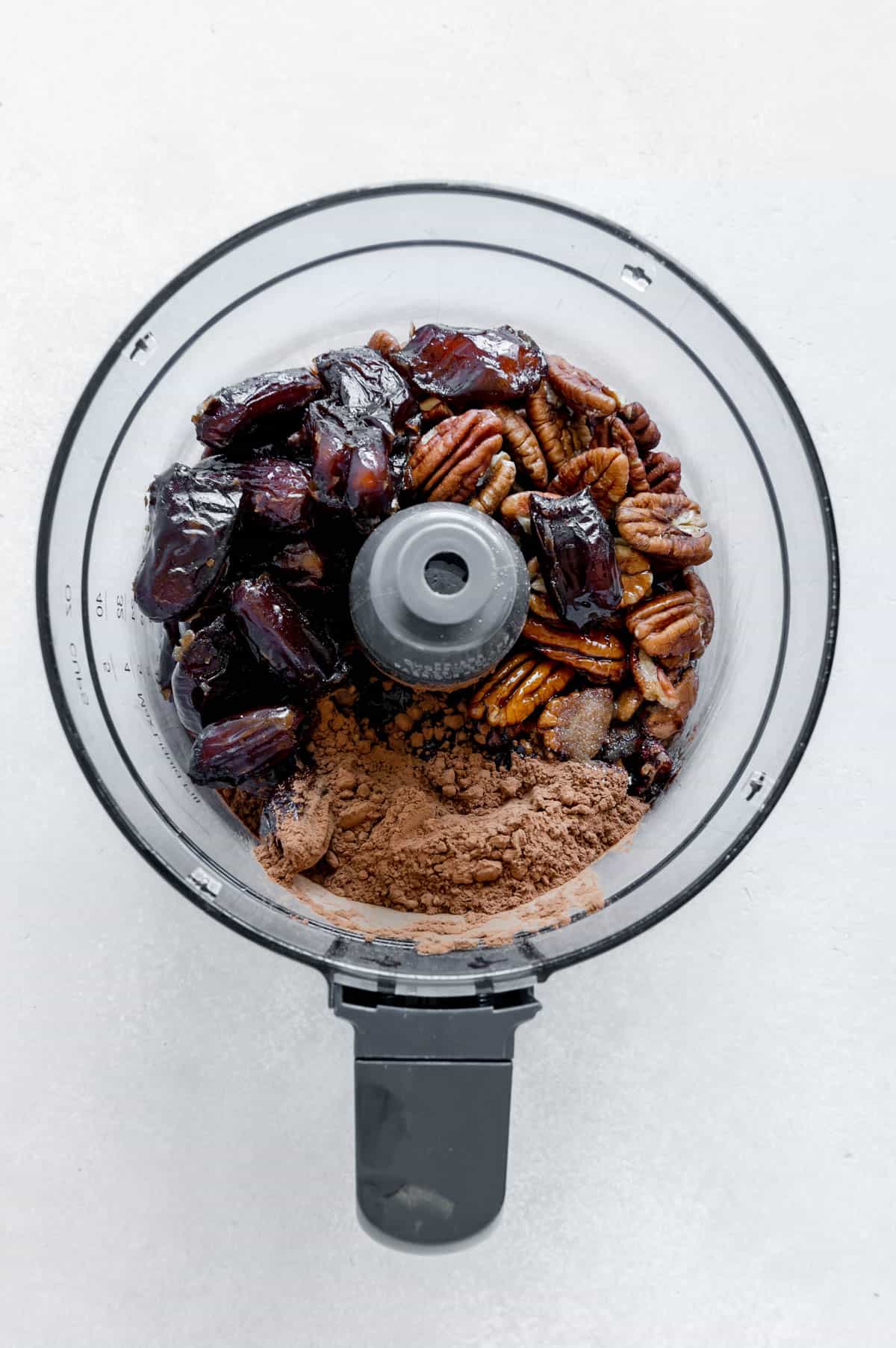 Ingredients for a pecan crust in a food processor.