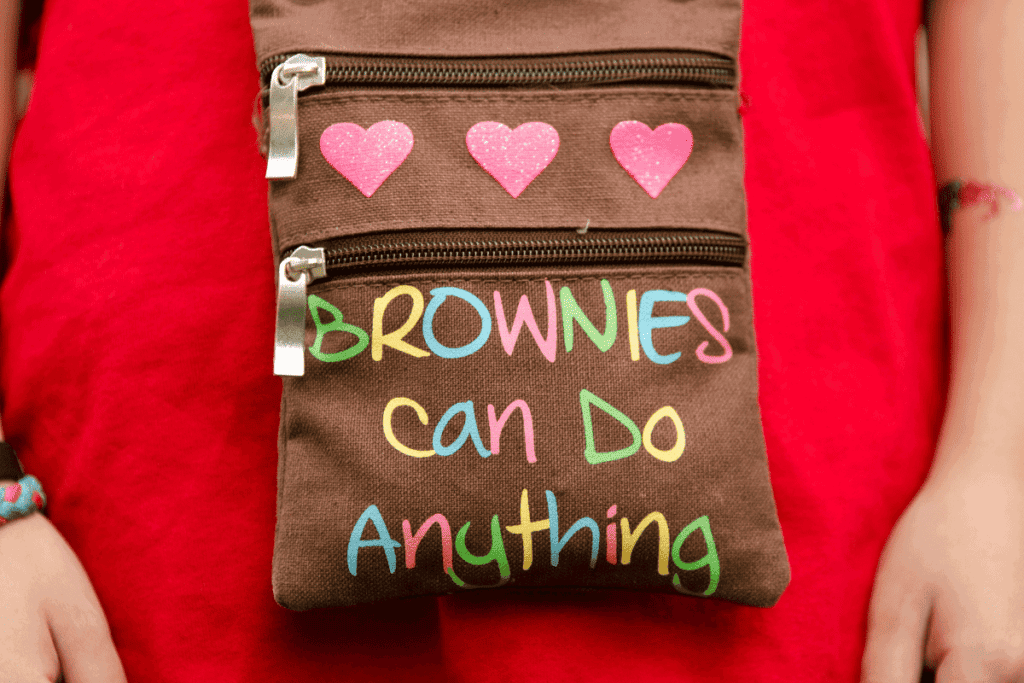 A Girl Scout with a bag that says "brownies can do anything."