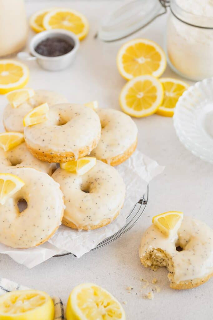 A serving platter of vegan lemon donuts with poppy seeds.