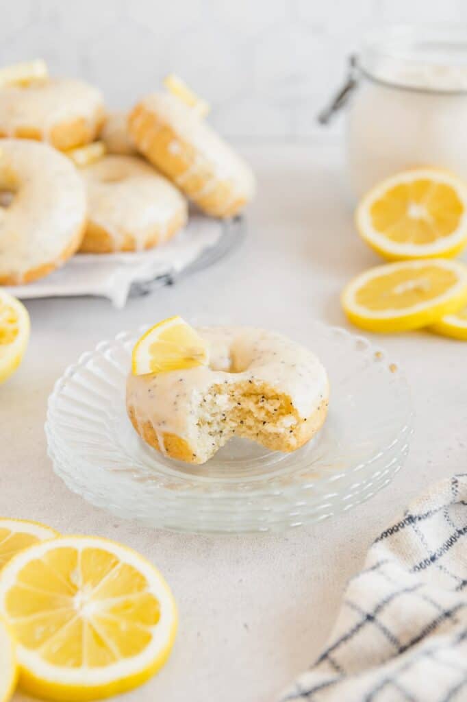 A vegan lemon donut with a bite taken out of it.