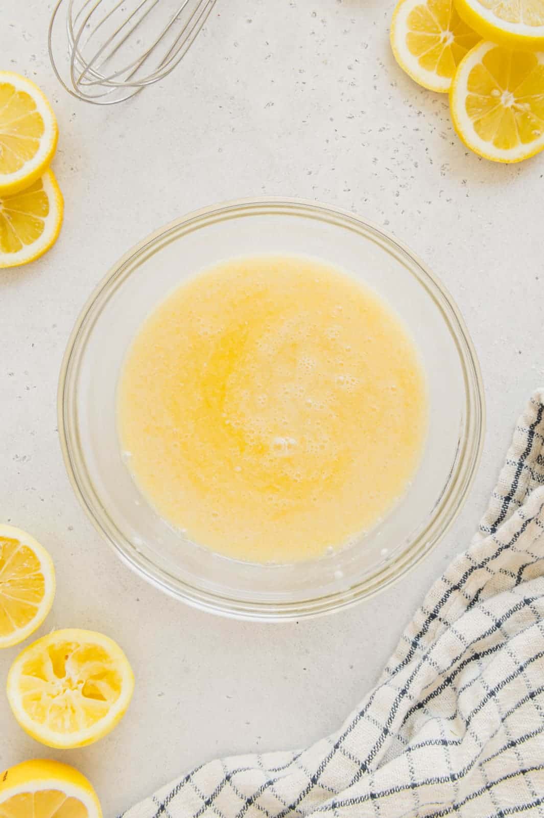 Wet ingredients for lemon donuts in a glass bowl.