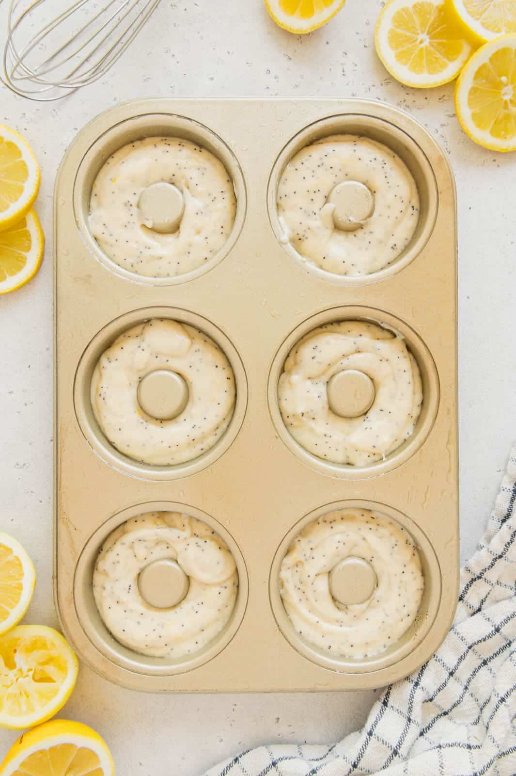 Lemon donuts in a donut baking tin ready to be baked.