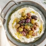 A stunning appetizer of whipped feta garnished with marinated olives.