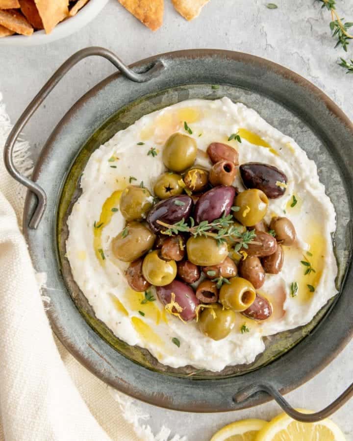A stunning appetizer of whipped feta garnished with marinated olives.