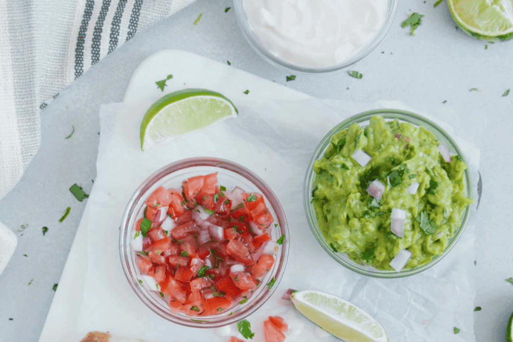 Salsa and guacamole garnished with onions and cilantro.