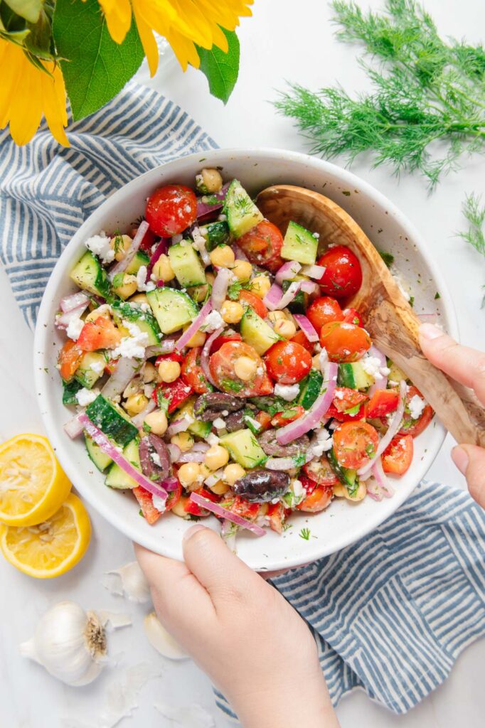 A chickpea salad being tossed.