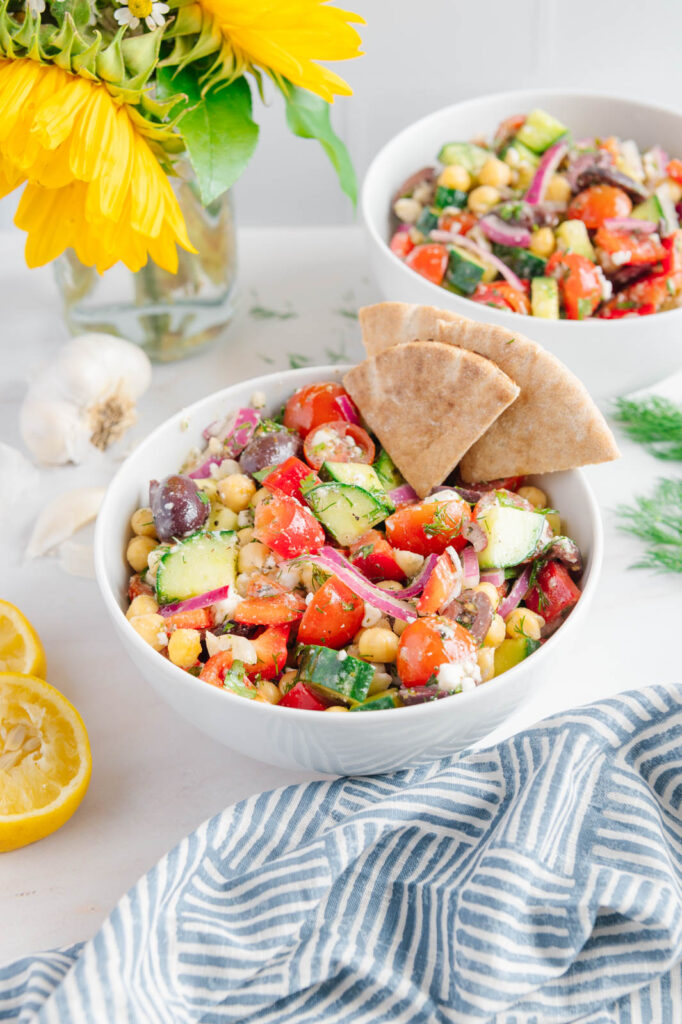 A bowl of Greek chickpea salad with fresh pita bread.