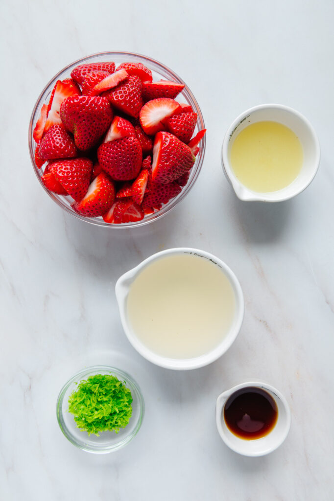 Ingredients to make strawberry lime popsicles in glass bowls.