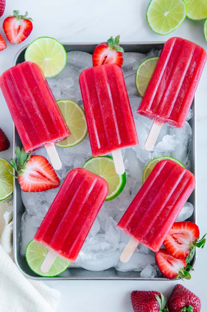Strawberry lime popsicles in an ice tray.