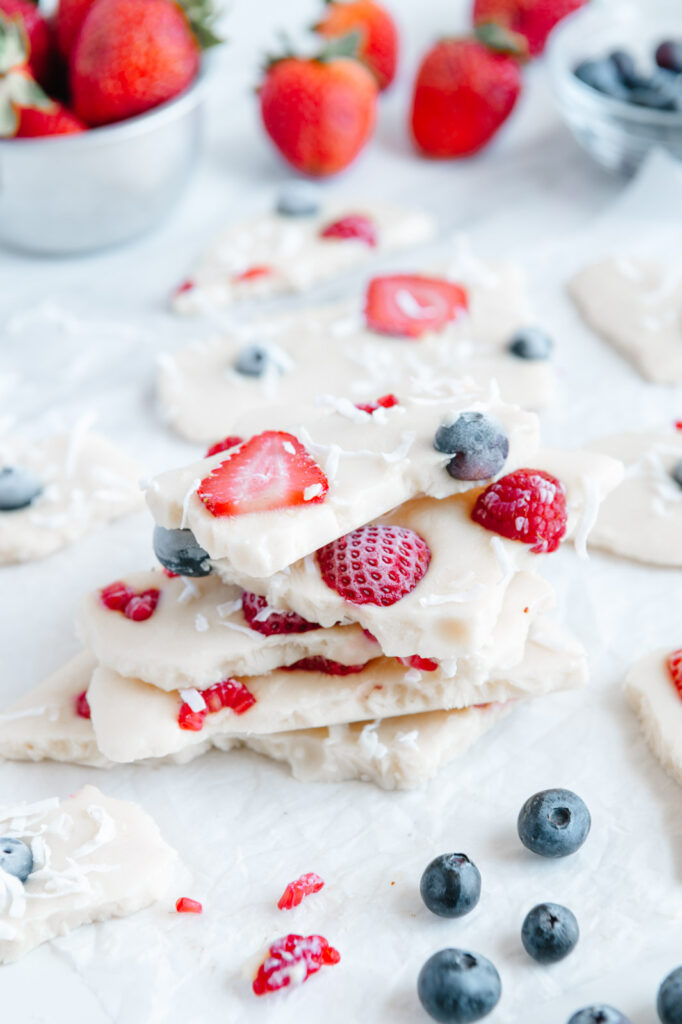 Several pieces of frozen yogurt bark with berries stacked on top of one another.