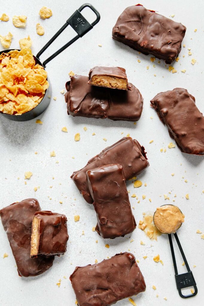 Butterfingers bars surrounded by almond butter and corn flakes.