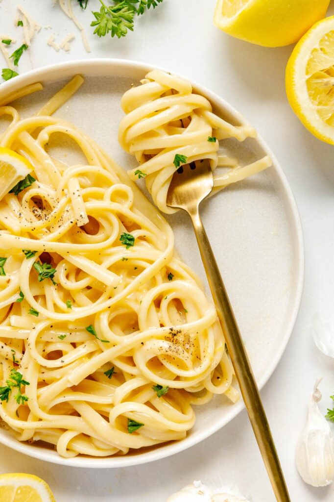 Creamy lemon pasta swirled around a fork.