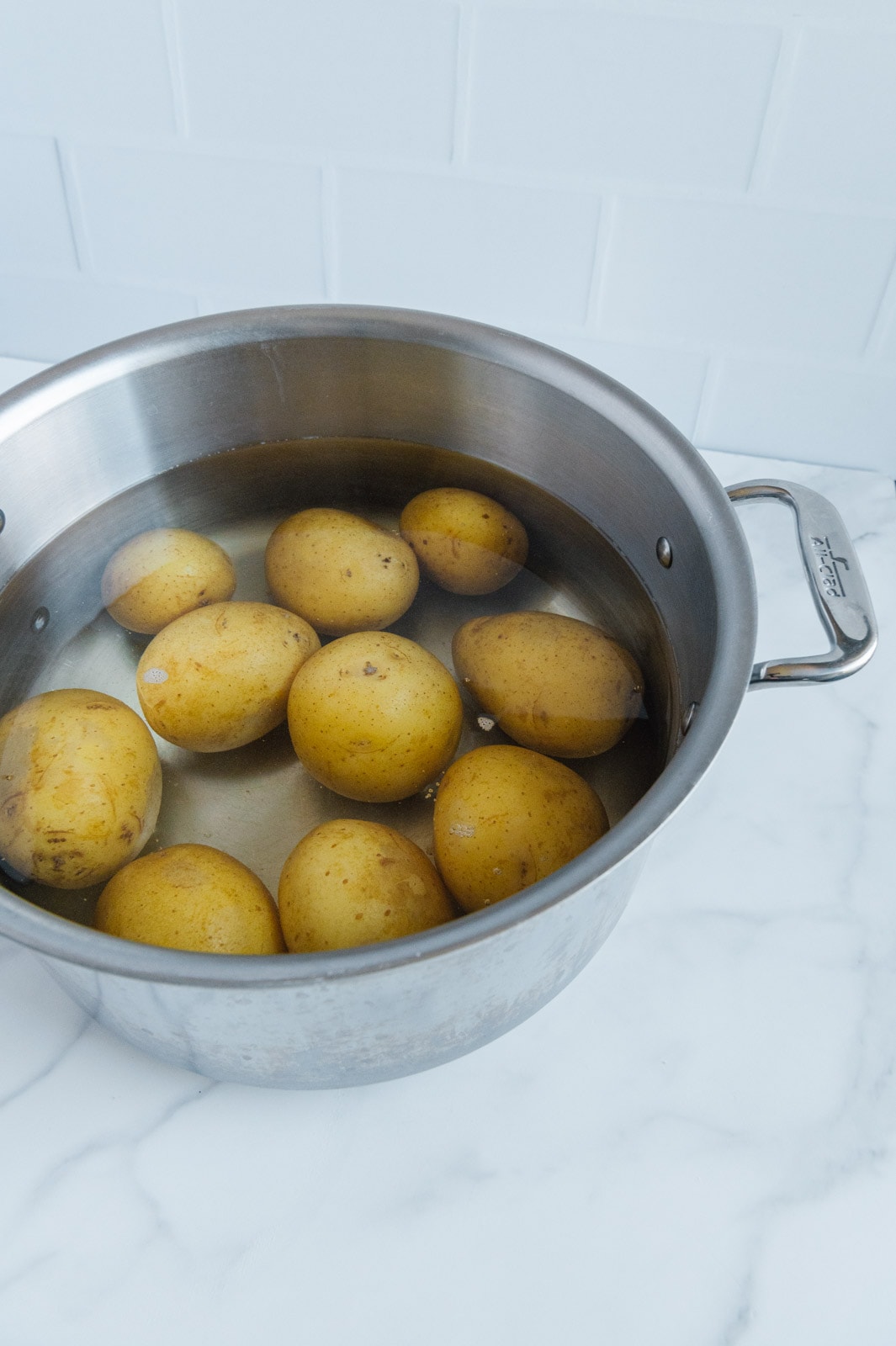 Gold Yukon potatoes cooking in a pot of water.