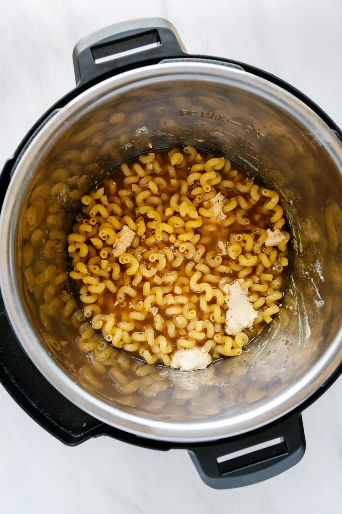 Cavatappi noodles with water, butter, and spices in an Instant Pot.