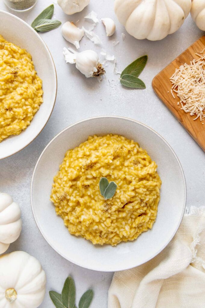 A bowl of pumpkin risotto with fresh cracked pepper and sage.