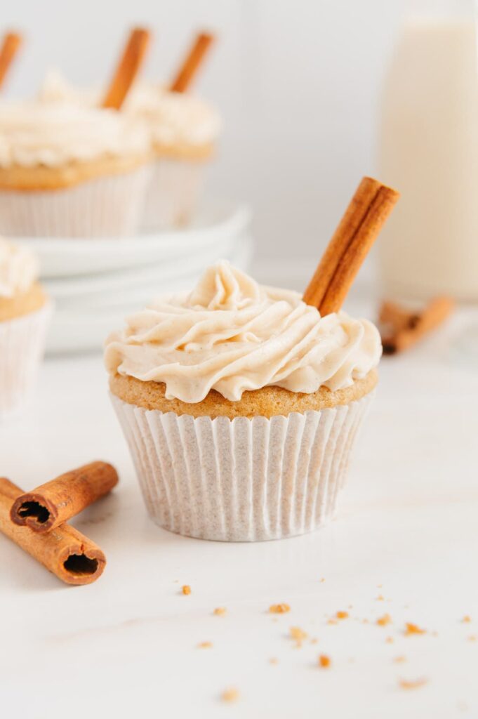A chai cupcake with chai buttercream frosting and a cinnamon stick sticking out of it.
