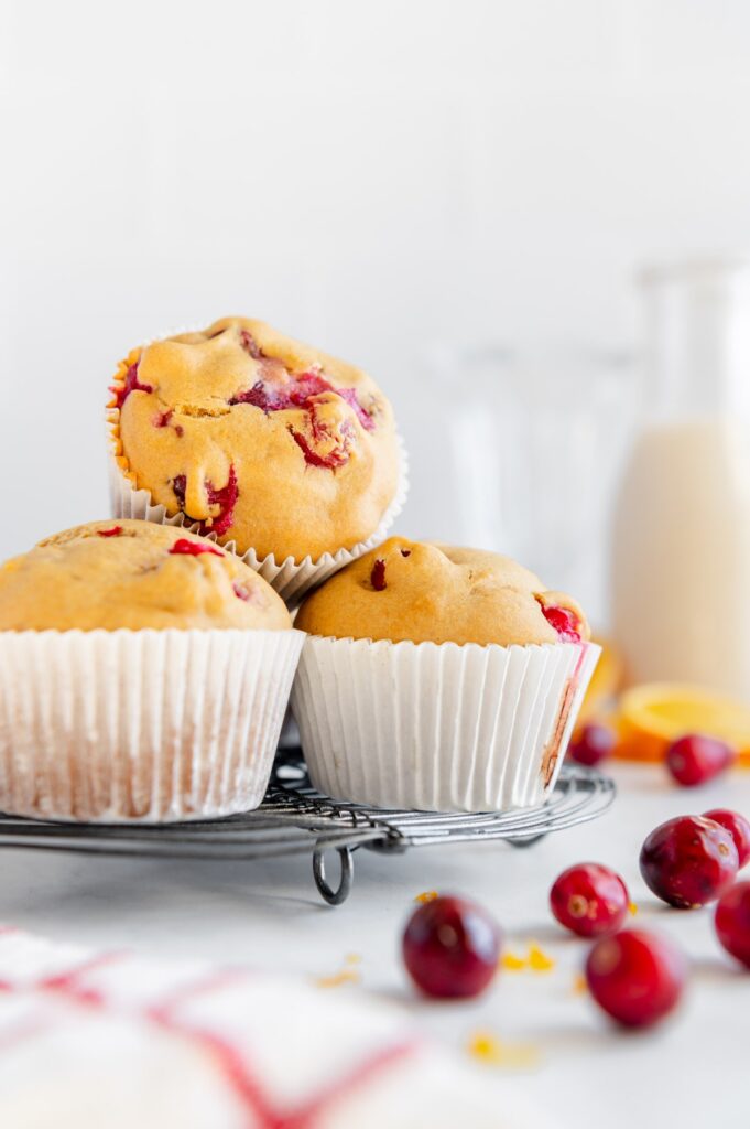 A stack of cranberry orange muffins on a cooling rack.