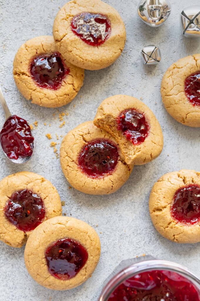 Scattered peanut butter and jelly thumbprint cookies.