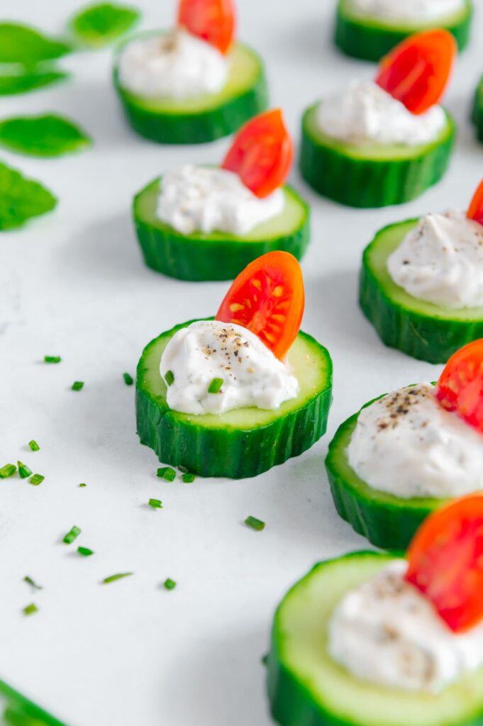 Cucumber bites topped with a fresh tomato half.