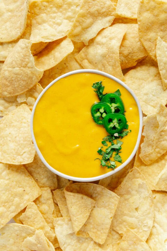 Vegan nacho cheese surrounded by tortilla chips.