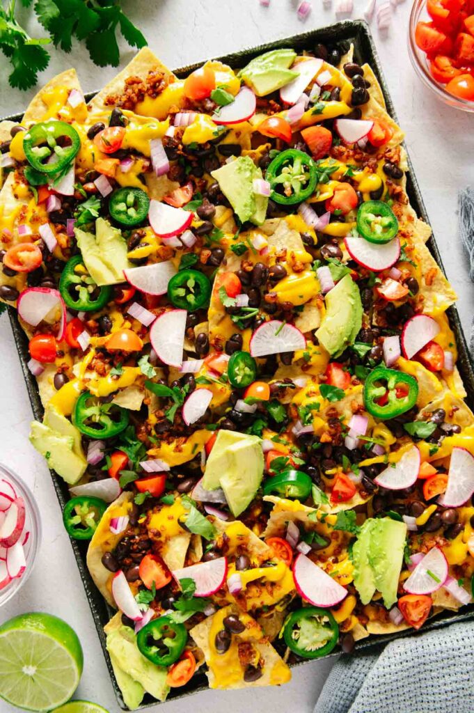 A sheet pan full of nachos that are vegan with all of the toppings.