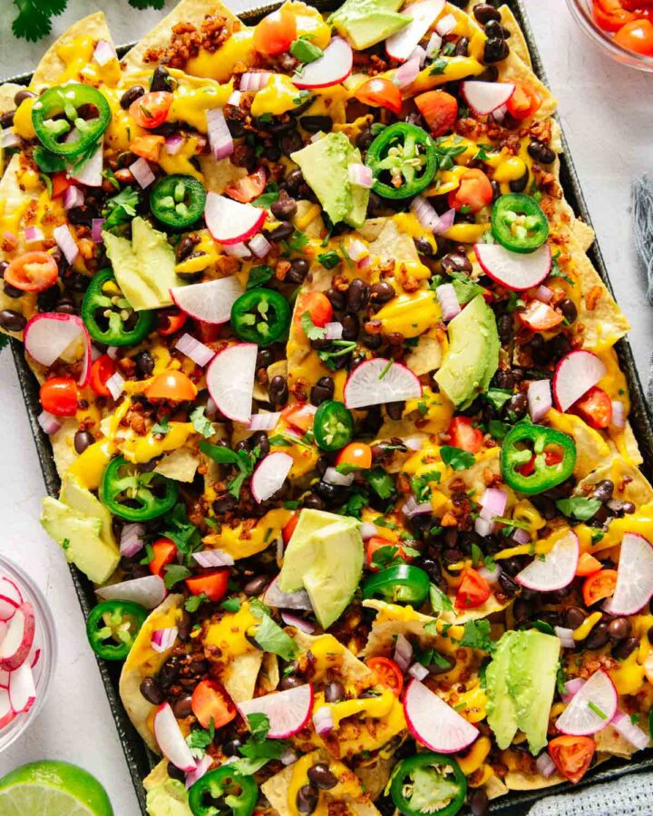 A sheet pan full of nachos that are vegan with all of the toppings.