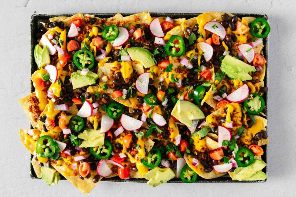 Sheet pan nachos loaded up with all of the toppings.