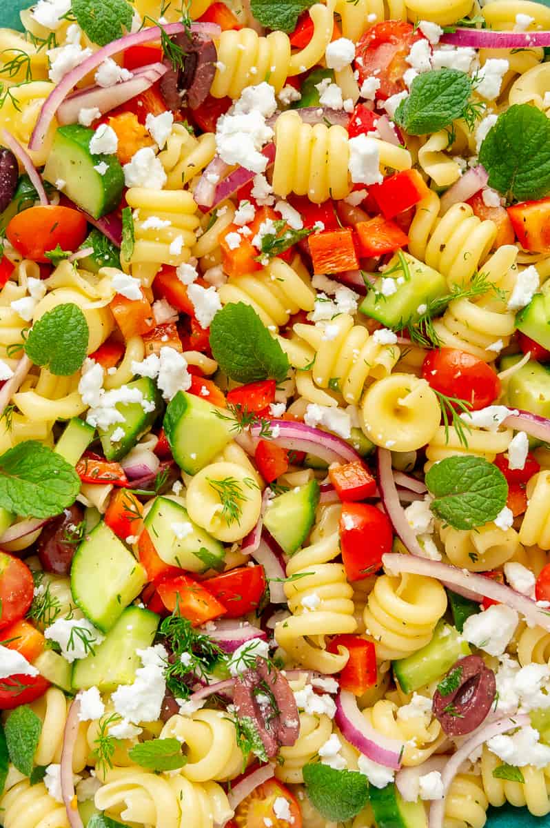 Upclose of the textures and different veggies in a Mediterranean pasta salad.
